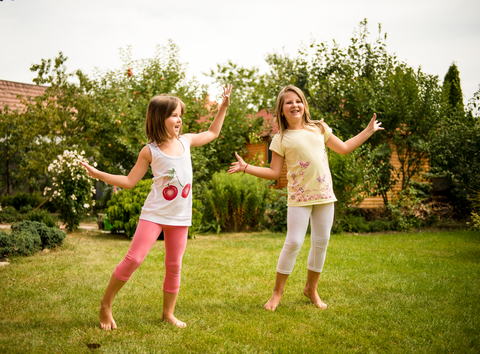 Children dancing happily in a yard