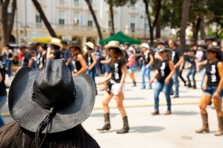 Black hat and group country dancing on city street